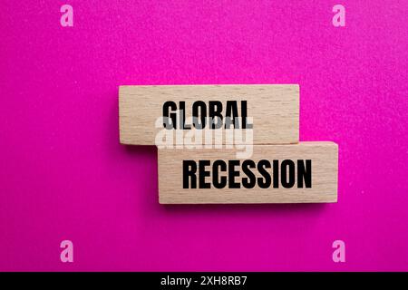 Messaggio di recessione globale scritto su blocchi di lana con sfondo rosa. Simbolo di recessione globale concettuale. Copia spazio. Foto Stock