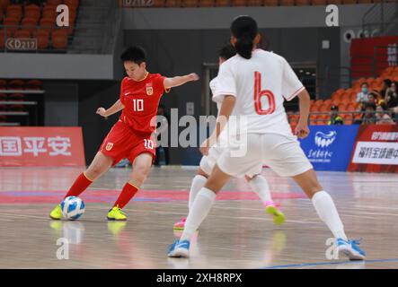 Lanzhou, la provincia cinese del Gansu. 12 luglio 2024. Shen Nan (L) della Cina spara la palla durante la partita tra Cina e Vietnam al torneo internazionale di Futsal femminile 2024 di CFA 'LANZHOU OLYMPIC' Cup a Lanzhou, nella provincia di Gansu, nel nord-ovest della Cina, 12 luglio 2024. Crediti: Zhang Rui/Xinhua/Alamy Live News Foto Stock