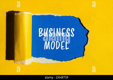 Messaggio del modello aziendale scritto su carta gialla strappata con sfondo blu. Simbolo del modello di business concettuale. Copia spazio. Foto Stock