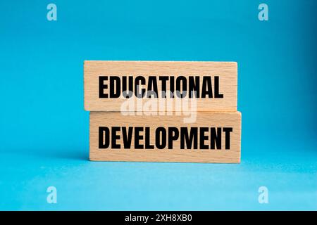 Messaggio di sviluppo educativo scritto su blocchi di legno con sfondo blu. Simbolo dello sviluppo concettuale educativo. Copia spazio. Foto Stock