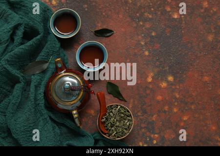 Composizione con teiera tradizionale e tazze di puer tea aromatico su fondo marrone Foto Stock