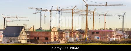 Eine Baustelle im Neubaugebiet in einem Neubaugebiet stehen viele Baukräne und Häuser im Rohbau *** Un cantiere in una nuova area di sviluppo in una nuova Foto Stock