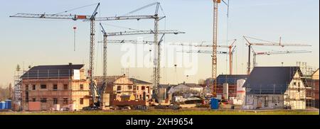 Eine Baustelle im Neubaugebiet in einem Neubaugebiet stehen viele Baukräne und Häuser im Rohbau *** Un cantiere in una nuova area di sviluppo in una nuova Foto Stock