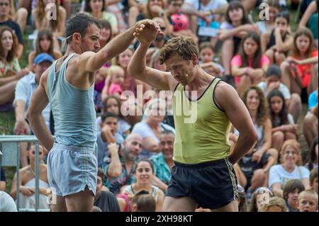 Viladecasn, SPAGNA - 12 LUGLIO 2024: Due atleti si tengono per mano in un evento sportivo di massa, che illustra lo spirito sportivo e il rispetto dello sport. Foto Stock