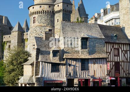 Il francese la città medievale di Vitre, Brittany. Il castello di Vitre Chateau sorge dietro il graticcio facciata dell'Auberge du Chateau Foto Stock