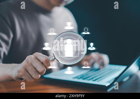 CRM aziendale o Customer Relationship Management e concetto di gruppo target focalizzato sul cliente, l'uomo d'affari utilizza una lente di ingrandimento per trovare l'icona umana. cliente, autobus Foto Stock