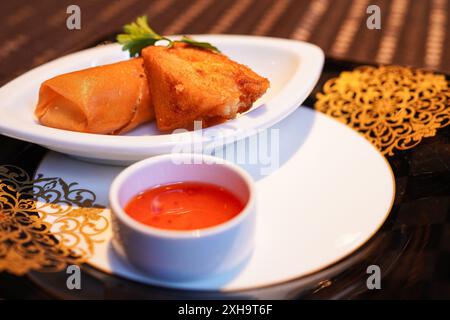 Involtini primavera cinesi e pane fritto con pasta di gamberi preparati da uno chef di un autentico ristorante cinese Foto Stock