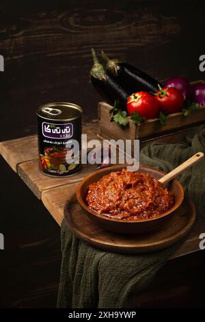 Stufato tradizionale di melanzane iraniane in una ciotola di legno con ingredienti freschi Foto Stock