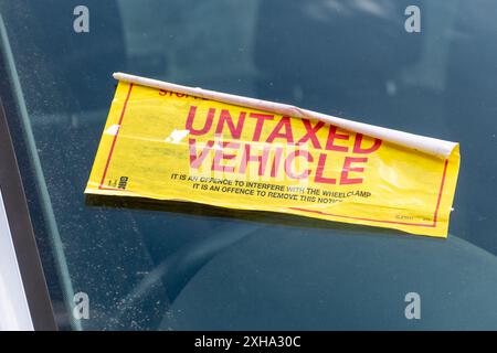 Adesivo DVLA veicolo non tassato su un'auto dotata di un morsetto per ruota, Regno Unito Foto Stock