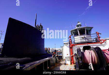 Il sottomarino d'attacco rapido classe Virginia USS Minnesota (SSN 783) è trainato dal rimorchiatore ASD Neil Abercrombie dal lato del molo per iniziare le prove in mare, Pearl Harbor, Hawaii, 20 giugno 2024. Il Minnesota è entrato in un attracco esteso Selected Restricted Availability (EDSRA) presso Pearl Harbor Naval Shipyard and Intermediate Maintenance Facility (PHNSY & IMF) quasi 25 mesi fa. Durante il periodo di manutenzione, il cantiere navale e l'equipaggio hanno eseguito il brillamento e il rivestimento dei serbatoi, la conservazione dello scafo, la propulsione e le riparazioni dei sistemi navali, l'ammodernamento e l'apporto di miglioramenti agli impianti meccanici ed elettrici. Di seguito Foto Stock