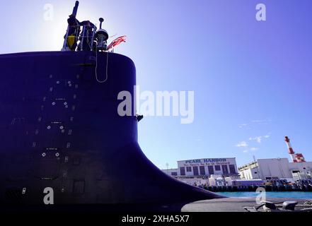 Il sottomarino d'attacco rapido classe Virginia USS Minnesota (SSN 783) viene trainato per iniziare le prove in mare mentre passa davanti al cantiere navale di Pearl Harbor e al centro di manutenzione intermedio a Pearl Harbor, Hawaii, 20 giugno 2024. Il Minnesota è entrato in un attracco esteso Selected Restricted Availability (EDSRA) presso Pearl Harbor Naval Shipyard and Intermediate Maintenance Facility (PHNSY & IMF) quasi 25 mesi fa. Durante il periodo di manutenzione, il cantiere navale e l'equipaggio hanno eseguito il brillamento e il rivestimento dei serbatoi, la conservazione dello scafo, la propulsione e le riparazioni del sistema navale, gli ammodernamenti e apportato miglioramenti ai meccanici Foto Stock