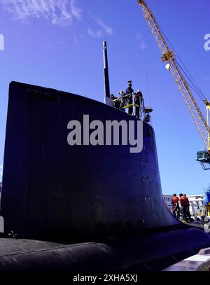 I membri del gruppo del ponte in cima alla vela del sottomarino ad attacco rapido classe Virginia USS Minnesota (SSN 783) osservano mentre sono trainati dal molo per iniziare le prove in mare, Pearl Harbor, Hawaii, 20 giugno 2024. Il Minnesota è entrato in un attracco esteso Selected Restricted Availability (EDSRA) presso Pearl Harbor Naval Shipyard and Intermediate Maintenance Facility (PHNSY & IMF) quasi 25 mesi fa. Durante il periodo di manutenzione, il cantiere navale e l'equipaggio hanno eseguito il brillamento e il rivestimento dei serbatoi, la conservazione dello scafo, la propulsione e le riparazioni del sistema navale, gli aggiornamenti di modernizzazione e apportato miglioramenti ai sistemi meccanici e Foto Stock