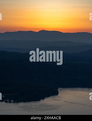 Un'immagine del vecchio di Conistone al tramonto, con un lago nebbioso windermere in primo piano. Foto Stock