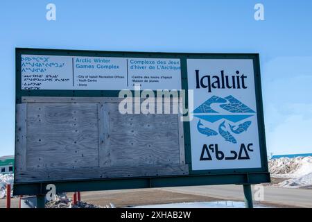 Il complesso dei Giochi invernali artici multilingue firma in inglese, francese e inuktitut su Niaqunngusiariaq a Iqaluit, Nunavut, Canada Foto Stock