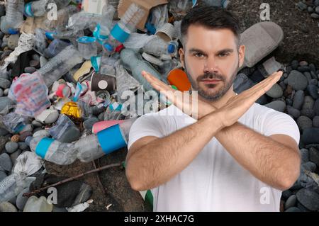 Inquinamento ambientale. Uomo che mostra un gesto di stop. Spazzatura sullo sfondo Foto Stock