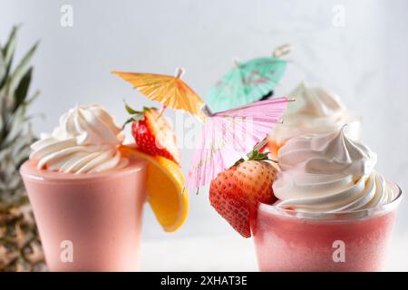 Una vista di ombrelli per bevande di carta che decorano una selezione di frullati di frutta. Foto Stock