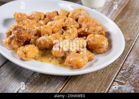 Vista di un piatto di ali di pollo disossate in salsa all'aglio. Foto Stock