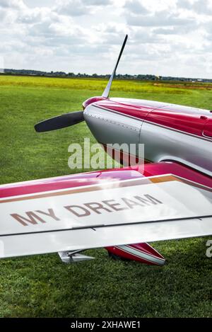 Dettaglio piano aerobatico rosso su erba verde pronto per il volo Foto Stock