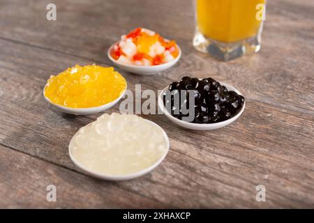 Una vista di diversi piattini di frutta, tè e bevande, con boba e gelatina. Foto Stock