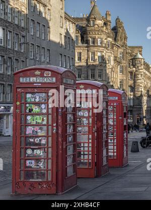 Edimburgo, Scozia - 19 gennaio 2024 - tre cabine telefoniche rosse di fila sul Royal Mile. Iconico telefono rosso tradizionale britannico, classico telefono rosso Foto Stock