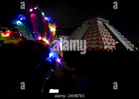 Città del Messico, Messico. 12 luglio 2024. Le persone con pennacchi e luci guardano una replica della Piramide di Chichén Itzá a città del Messico, Messico, il 1° ottobre 2022, dove si sta svolgendo uno spettacolo con proiezioni 2D e 3D sulla struttura. L'evento è organizzato dal Ministero della Cultura e la sua prima rappresentazione è intitolata ''The Mayan People and Felipe Carrillo Puerto. Memoria luminosa II''. (Foto di Gerardo Vieyra/NurPhoto) credito: NurPhoto SRL/Alamy Live News Foto Stock