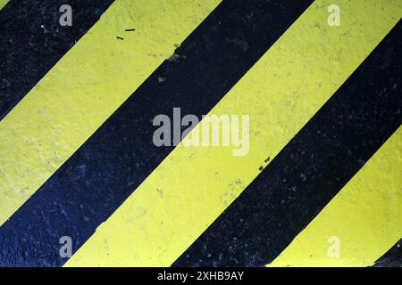 Dettaglio di una soglia di colore giallo e nero con linee diagonali. Inteso come sfondo grunge giallo-nero Foto Stock