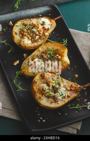 Pere al forno con formaggio blu, noci, miele e timo. Sana cucina francese Appetiser Foto Stock