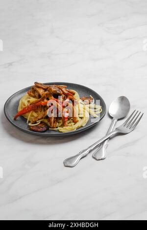 Piatto con spaghetti con funghi e maiale in salsa appiccicosa Foto Stock