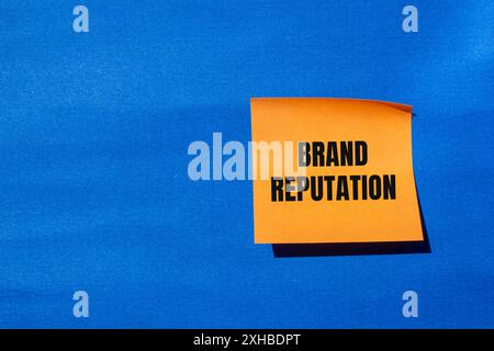 Messaggio sulla reputazione del marchio scritto su carta arancione con sfondo blu. Simbolo concettuale della reputazione del marchio. Copia spazio. Foto Stock