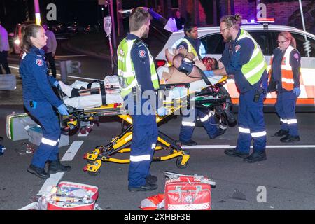 Sydney, Australia. 13 luglio 2024. Si è verificata una devastante collisione tra un motociclista e un giovane pilota di scooter all'intersezione tra Birrell Street e Carrington Road a Waverley, nei sobborghi orientali di Sydney. L'area è conosciuta per il suo gran numero di motociclisti che effettuano consegne di cibo su scooter e biciclette. Nella foto: Un pilota gravemente ferito viene assistito dai paramedici. Crediti: Robert Wallace / Wallace Media Network / Alamy Live News Foto Stock