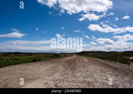 Strada sterrata e sabbiosa in una giornata soleggiata e blu del cielo. Fase e inizio del percorso e nuovi inizi Foto Stock