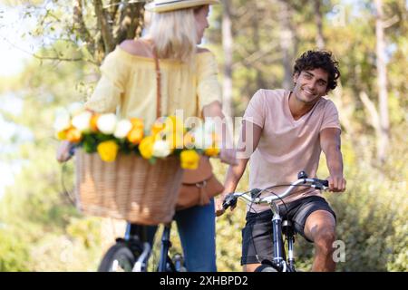 felice coppia che si inseguono a vicenda in bicicletta Foto Stock