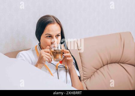 il medico prende una pausa tè, mostrando l'importanza del relax e del benessere mentale Foto Stock