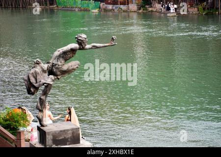 Man Jump statua al fiume tuojiang e al paesaggio urbano edificio storico architettura storica della città antica di Xiangxi Phoenix o città vecchia antica di fenghuan Foto Stock