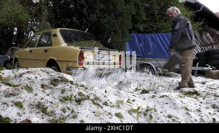 Ein extremes Hagelunwetter samt Orkan wütete am Freitagabend in der Ortschaft Brunnthal und der Gemeinde Höhenkirchen-Siegertsbrunn. Gegen 21:30 Uhr fegte eine gewaltige Unwetterfront über die Region hinweg. Im Gepäck norme Hagelmassen. In den Ortschaften fiel zu viel Hagel, dass die Gullys verstopften. Vom Sommer in den Winter in kurzer Zeit: Amateuraufnahmen zeigen, wie große Eisschollen durch Höhenkirchen-Siegertsbrunn schwimmen. Tiefster Winter Mitten im Sommer Auch knapp 20 Stunden nach dem schlimmen Unwetter liegt der Hagel noch meterhoch. Große Hagelberge findet man an Grundstücken. Di Foto Stock