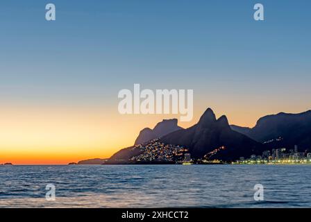 Edifici illuminati al tramonto sulla spiaggia di Ipanema a Rio de Janeiro, sulla spiaggia di Ipanema, Rio de Janeiro, Rio de Janeiro, Brasile Foto Stock