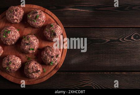 Polpette crude, con micro vegetazione, su un tagliere, fatte in casa, rustiche, senza persone Foto Stock