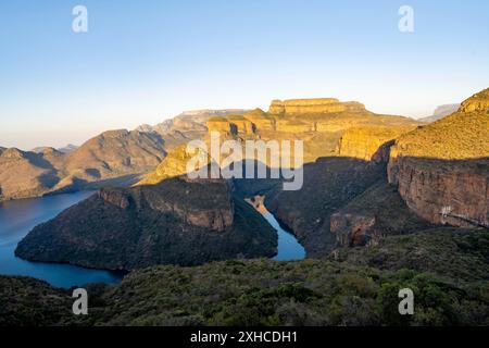 Tramonto al Blyde River Canyon con GIpfel Three Rondawels, vista del canyon con il fiume Blyde e le montagne Mesa alla luce della sera, paesaggio del canyon Foto Stock