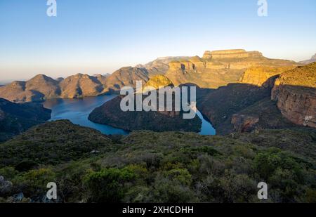 Tramonto al Blyde River Canyon con GIpfel Three Rondawels, vista del canyon con il fiume Blyde e le montagne Mesa alla luce della sera, paesaggio del canyon Foto Stock