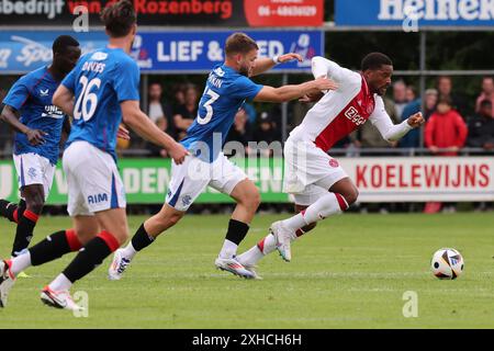 Wezep, Paesi Bassi. 13 luglio 2024. WEZEP, PAESI BASSI - 13 LUGLIO: Chuba Akpom dell'AFC Ajax combatte per il pallone con Nicolas Raskin dei Rangers FC durante la partita pre-stagionale tra AFC Ajax e Rangers FC a WHC il 13 luglio 2024 a Wezep, Paesi Bassi. (Foto di Peter Lous/Orange Pictures) credito: Orange Pics BV/Alamy Live News Foto Stock