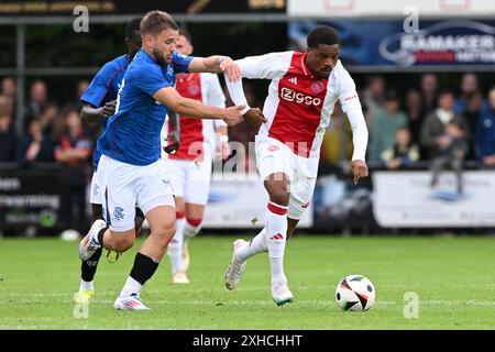 WEZEP - (l-r) Nicolas Raskin dei Rangers FC, Chuba Akpom dell'Ajax durante l'amichevole tra Ajax e Rangers FC allo Sportpark Mulderssingel il 13 luglio 2024 a Wezep, Paesi Bassi. ANP GERRIT VAN COLOGNE Foto Stock