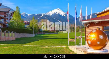 Bulgaria, grande palla gialla di Capodanno, Bansko vi ama e neve montagne banner panorama primavera Foto Stock