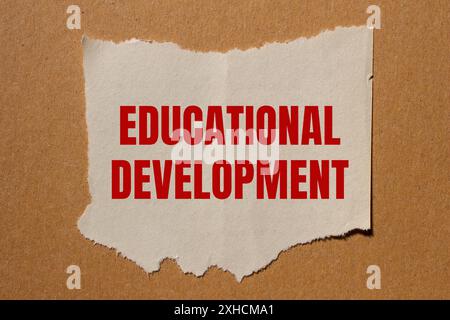 Messaggio di sviluppo educativo scritto su carta strappata con sfondo in cartone. Simbolo dello sviluppo concettuale educativo. Copia spazio. Foto Stock