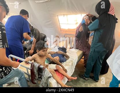 Khan Younis, Gaza. 13 luglio 2024. I palestinesi feriti individui che ricevono cure, compresi bambini e donne, vengono portati al Kuwait Field Hospital dopo l'attacco israeliano, a Khan Yunis, Gaza, sabato 13 luglio 2024, in cui sono state uccise 71 persone. Al-Mawasi era stata dichiarata zona sicura da Israele mentre persegue la sua offensiva militare in altre parti della Striscia di Gaza. Foto di Saber Arar/UPI credito: UPI/Alamy Live News Foto Stock