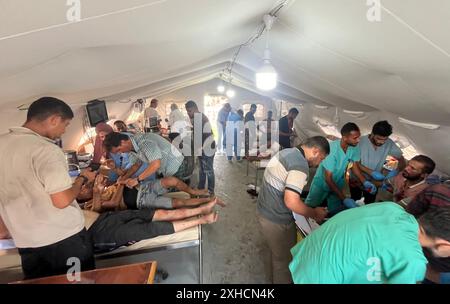 Khan Younis, Gaza. 13 luglio 2024. I palestinesi feriti individui che ricevono cure, compresi bambini e donne, vengono portati al Kuwait Field Hospital dopo l'attacco israeliano, a Khan Yunis, Gaza, sabato 13 luglio 2024, in cui sono state uccise 71 persone. Al-Mawasi era stata dichiarata zona sicura da Israele mentre persegue la sua offensiva militare in altre parti della Striscia di Gaza. Foto di Saber Arar/UPI credito: UPI/Alamy Live News Foto Stock