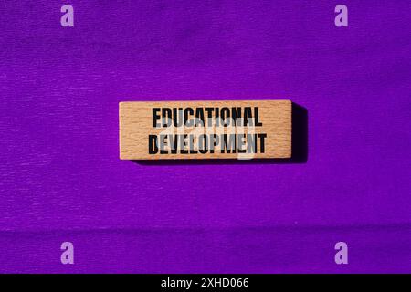 Messaggio di sviluppo educativo scritto su blocchi di legno con sfondo viola. Simbolo dello sviluppo concettuale educativo. Copia spazio. Foto Stock