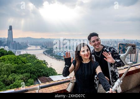 (240713) -- CHONGQING, 13 luglio 2024 (Xinhua) -- Ilia Anfilatov (R) e Syyra Alee registrano video nel comune di Chongqing, 12 luglio 2024. Gli studenti internazionali Ilia Anfilatov dalla Russia e Syyra Alee dal Pakistan studiano alla Southwest University di Chongqing da oltre un anno. Nel loro tempo libero, amano passeggiare per la città e condividere le loro esperienze sui social media. Grazie alla condivisione, molti dei loro amici e famiglie sono attratti dal bellissimo paesaggio e dalla cultura diversificata della Cina e hanno in programma di imbarcarsi in un viaggio in Cina ed esplorare il c Foto Stock