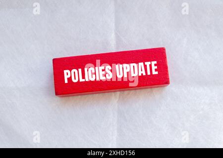Le policy aggiornano le parole scritte su un blocco di lana rossa con sfondo bianco. Simbolo di aggiornamento dei criteri concettuali. Copia spazio. Foto Stock