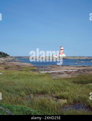 Faro di Pointe-des-Monts con bassa marea in estate, North Shore, Quebec, Canada Foto Stock