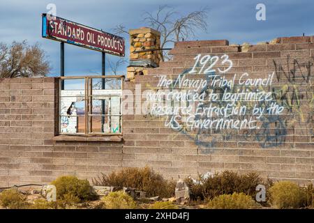 Una stazione di servizio abbandonata con una scritta di protesta Navajo sul muro. Foto Stock